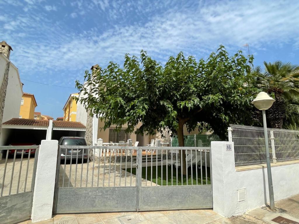 une clôture blanche avec un arbre en arrière-plan dans l'établissement VACACIONES CHALET PEÑISCOLA 8-B Alquiler, à Peñíscola