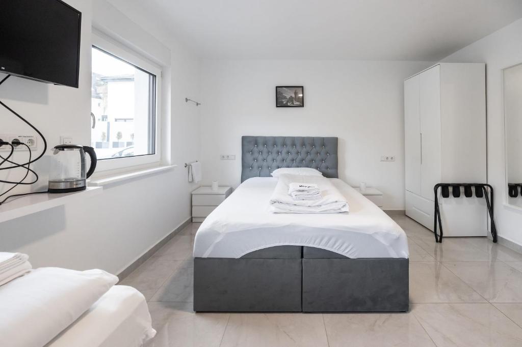 a white room with a bed and a window at House by StayStay I 24 Hours Check-In in Nuremberg