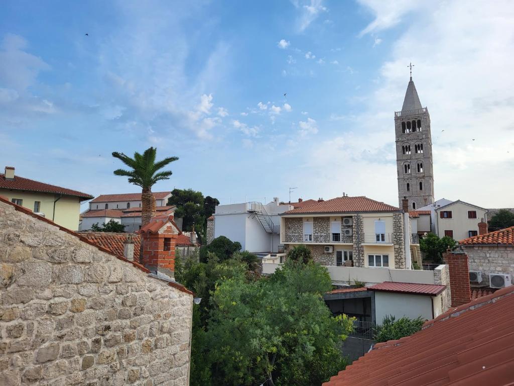 Blick auf eine Stadt mit einem Uhrturm in der Unterkunft Rab Stari grad in Rab