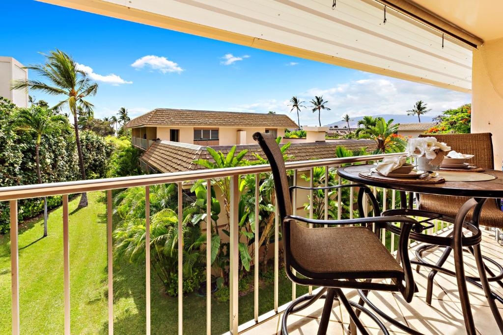 a patio with a table and chairs on a balcony at Kihei Kai Nani 368 in Kihei