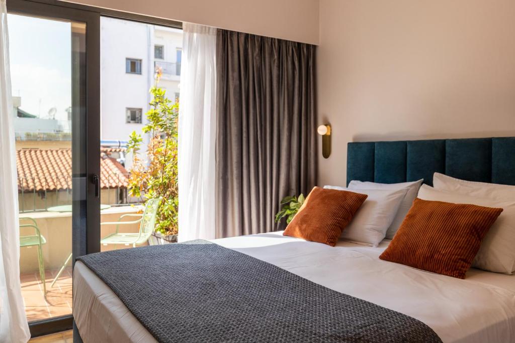 a bedroom with a large bed and a large window at L'Avventura Athens in Athens