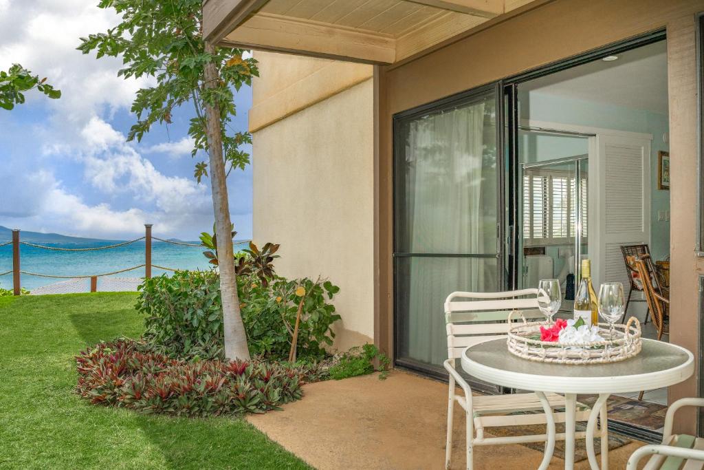 a table and chairs on a patio with a view of the ocean at Hono Kai A4 in Wailuku