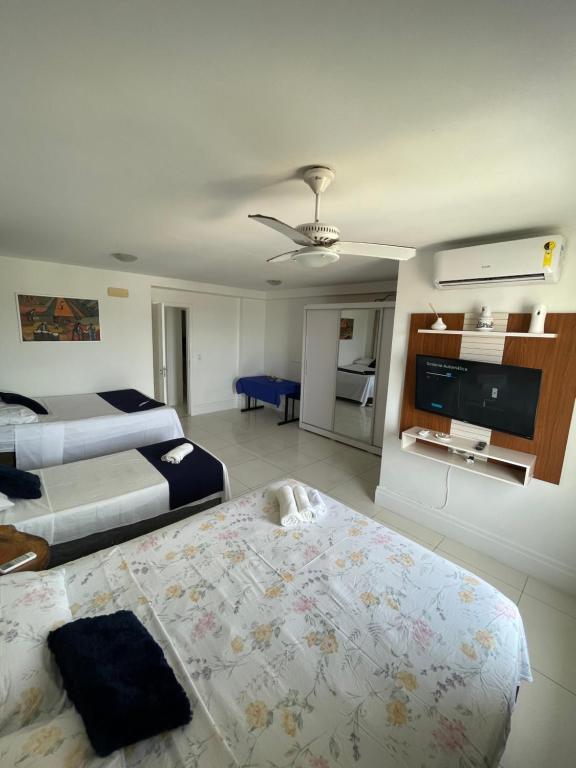 um quarto de hotel com duas camas e uma televisão de ecrã plano em Aptos atrás da Passarela do Caranguejo em Aracaju