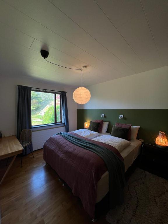 sypialnia z dużym łóżkiem i oknem w obiekcie House with a magical garden and sunroom w mieście Höfn