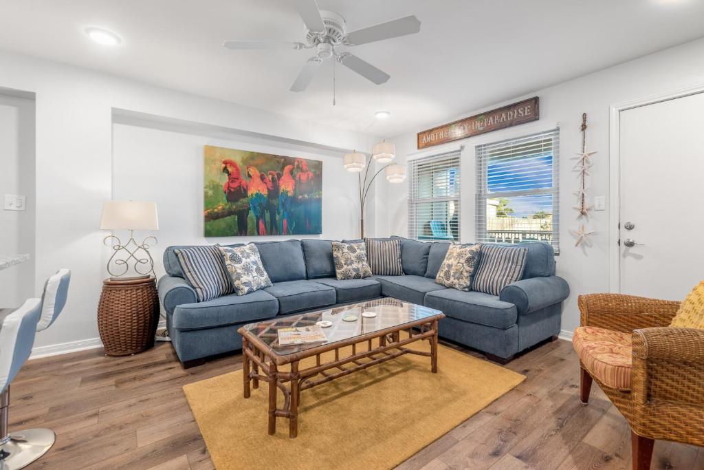 a living room with a blue couch and a table at Sunrise Villa 101 - Pool & Boardwalk to the beach in Port Aransas
