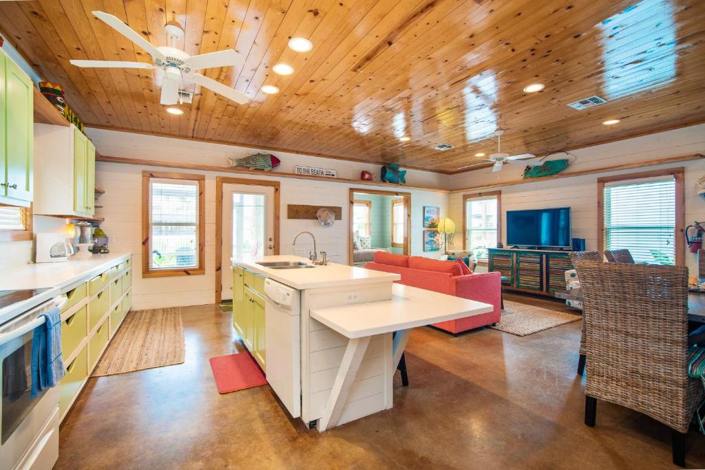 a kitchen with a sink and a living room at The RITZ Tarpon- VW 83 in Port Aransas
