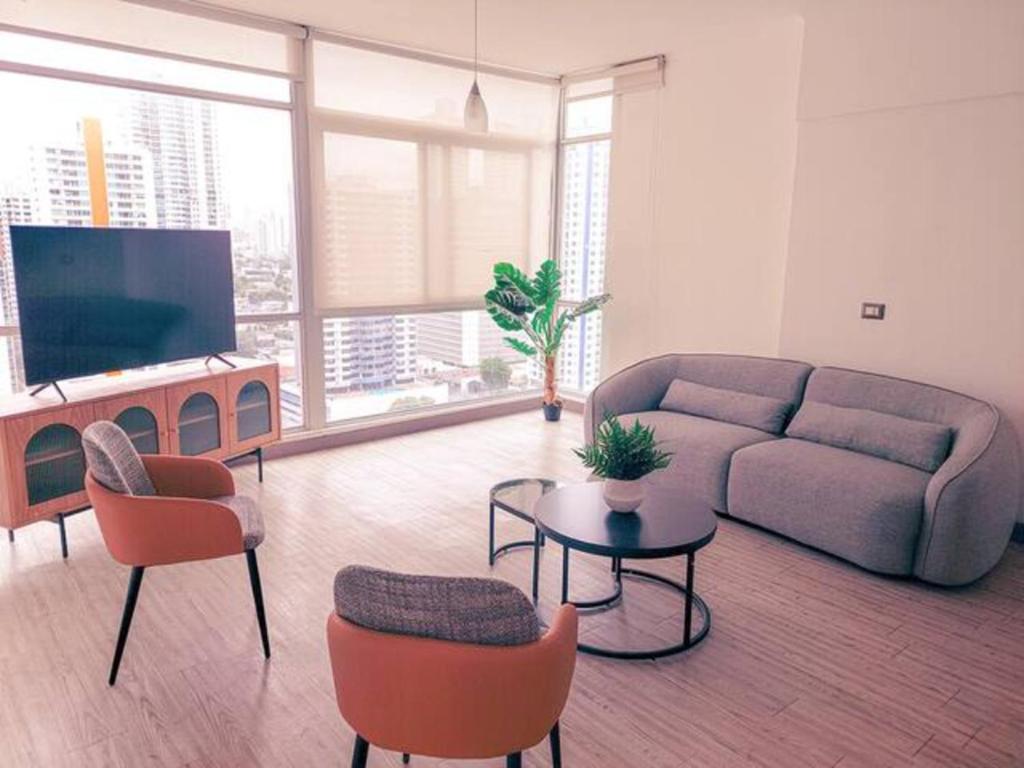 a living room with a couch and chairs and a tv at Luminous Excellence City Center - PH Quartier Atlapa in Panama City