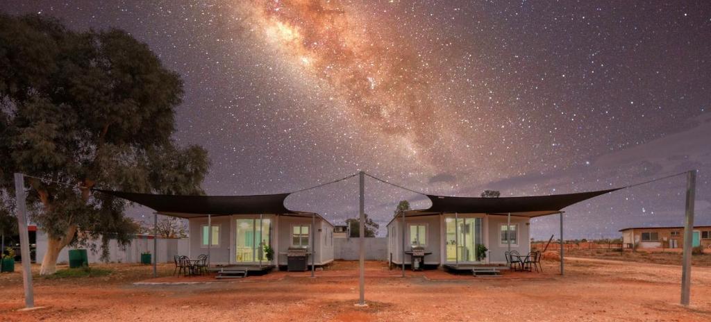 a starry night with the milky way above a house at White Cliffs Self Contained Cabin Accommodation in White Cliffs