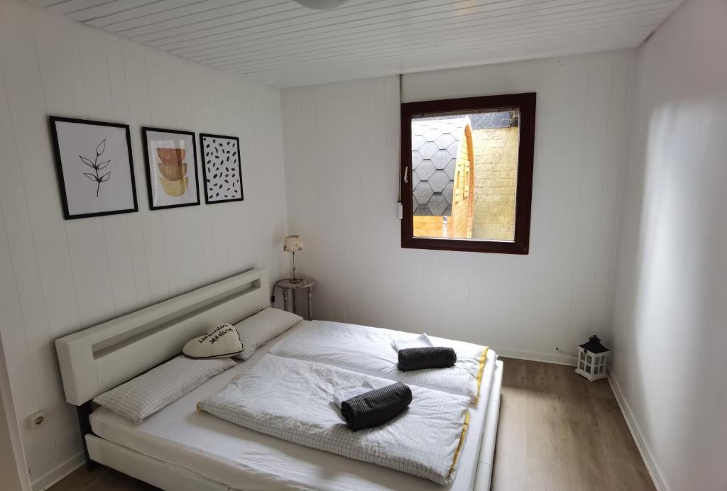 a white bedroom with a bed with a window at Ferienhaus mit Sauna in Molbergen