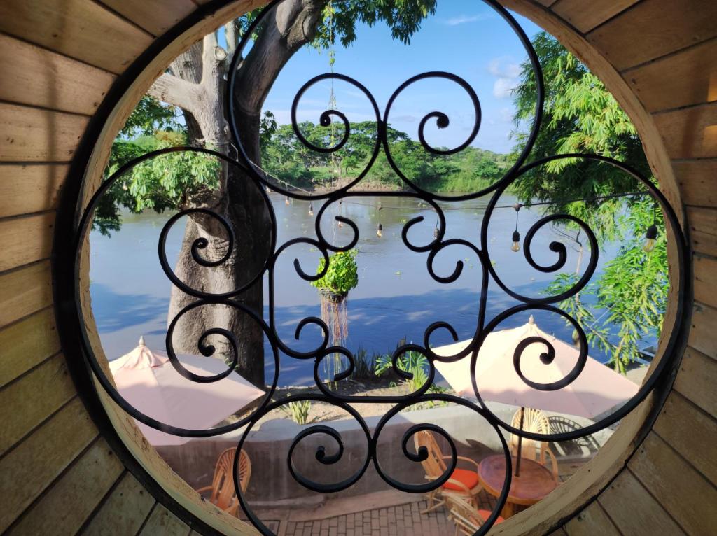 uma vista através de uma janela de ferro forjado com uma vista em HOTEL NIETO MOMPOX, ubicado en el corazón del centro histórico, frente al rio magdalena en zona de malecón em Mompos