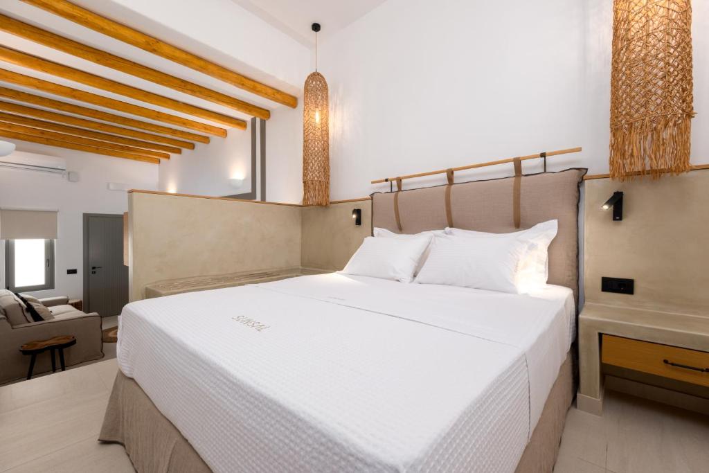 SunSal Luxury Studios - Earth في ناوسا: غرفة نوم بسرير ابيض كبير وكرسي