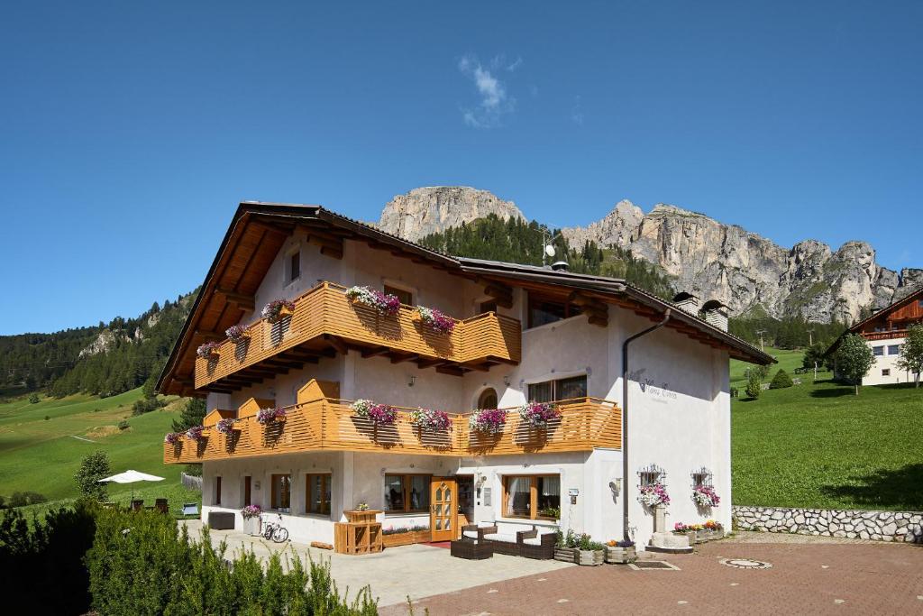 a large house with balconies on a mountain at Pensione Erica in Colfosco