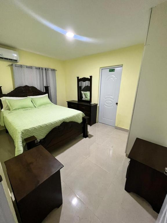 1 dormitorio con cama, mesa y puerta en Hotel La playa, en Santa Cruz de Barahona
