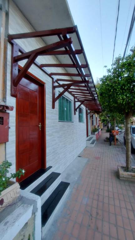 czerwone drzwi na boku budynku w obiekcie Casa da Árvore w mieście Arraial do Cabo