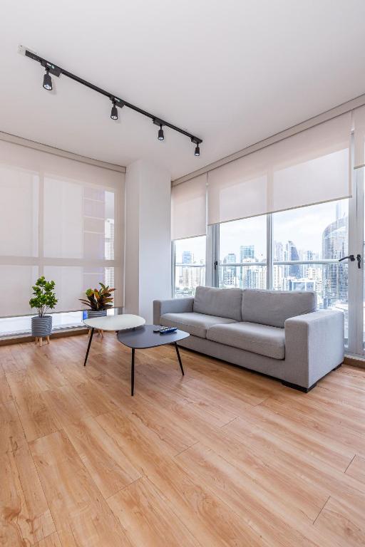 a white living room with a couch and a table at Impressive Family City View Apt B - PH Quartier Marbella in Panama City