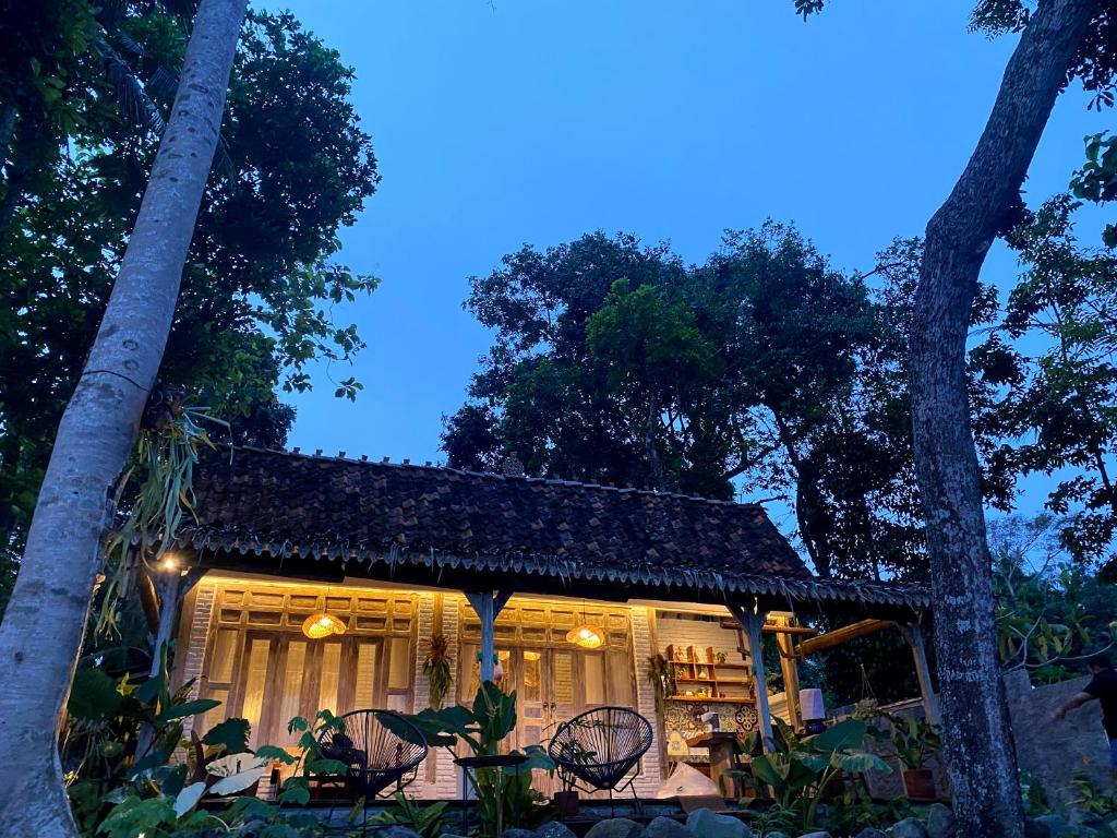 a house with a table and chairs and trees at Villa Sare - House with panorama rice field view in Yogyakarta