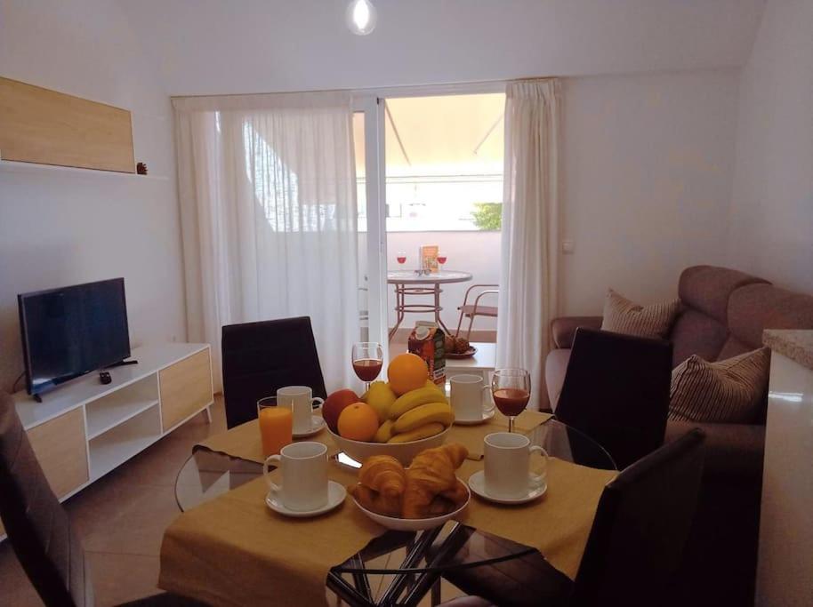 ein Wohnzimmer mit einem Tisch und einer Obstschale in der Unterkunft Oliver Atico Cano in Fuengirola