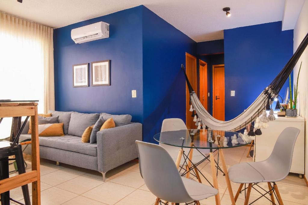 Sala de estar azul con sofá y hamaca en Lindo Apt no Jd das Américas en Cuiabá