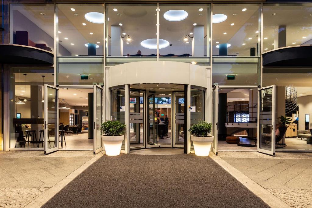 a building with two potted plants in front of it at Hotel Berlin, Berlin, a member of Radisson Individuals in Berlin