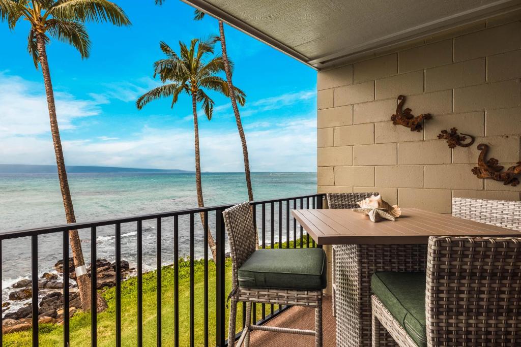 Noelani 206 في Kapalua-West Maui Airport: شرفة مع طاولة وكراسي والمحيط