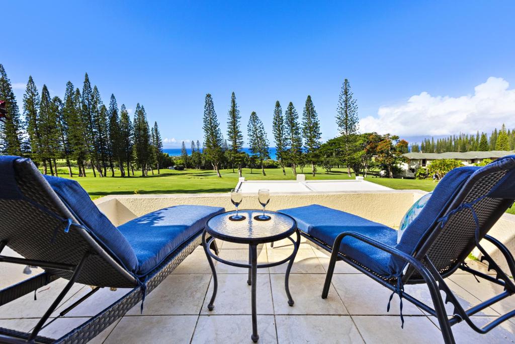 un patio con sillas, una mesa y una piscina en Kapalua Golf Villa 26P 5&6, en Kahana