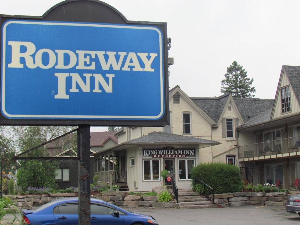 a blue road way inn sign in front of houses at Rodeway Inn King William Huntsville in Huntsville