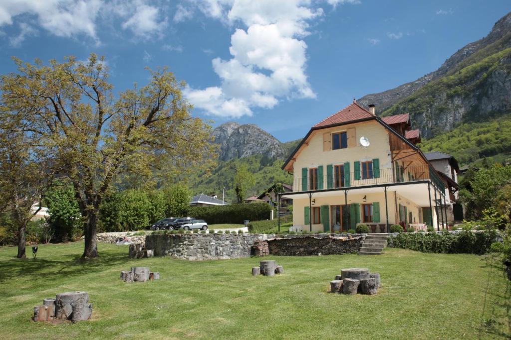 a house in a field with mountains in the background at Studio Des Sources - Vision Luxe in Veyrier-du-Lac