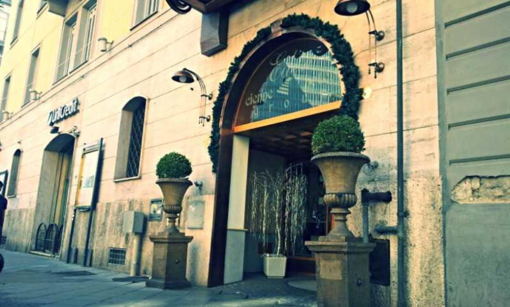 una entrada a un edificio con macetas. en Hotel Eden en Nápoles