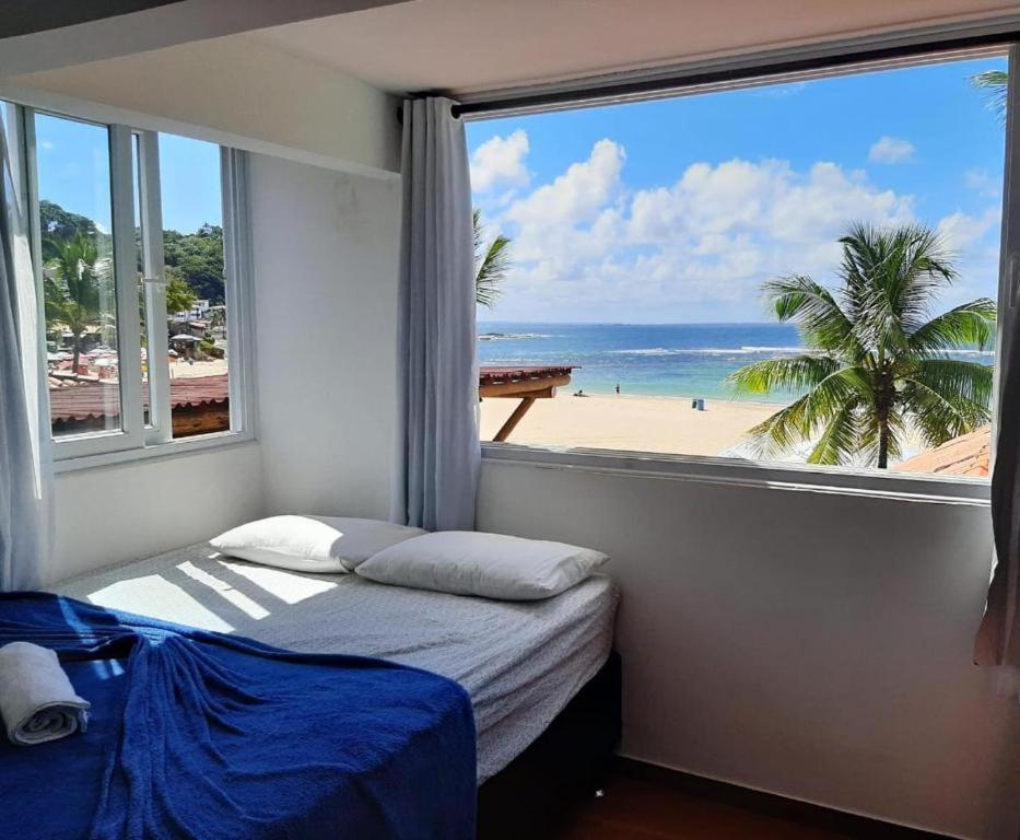 1 Schlafzimmer mit einem Fenster mit Blick auf den Strand in der Unterkunft Casa de Praia in Morro de São Paulo