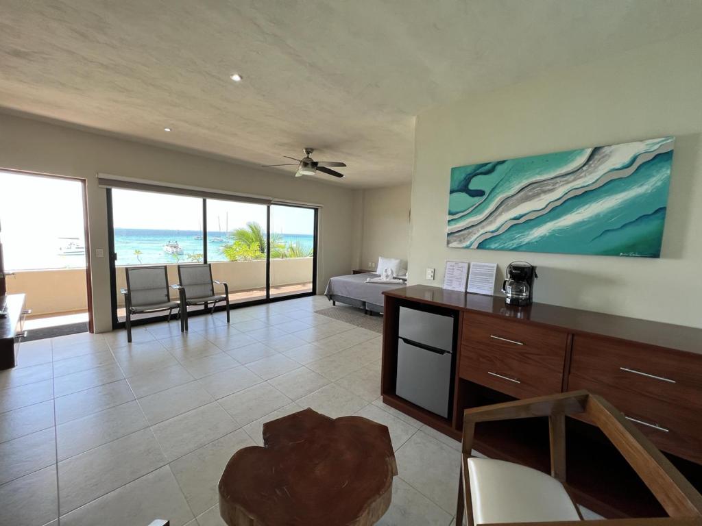 a living room with a bed and a view of the ocean at Cuxos Hotel Beachfront in Isla Mujeres