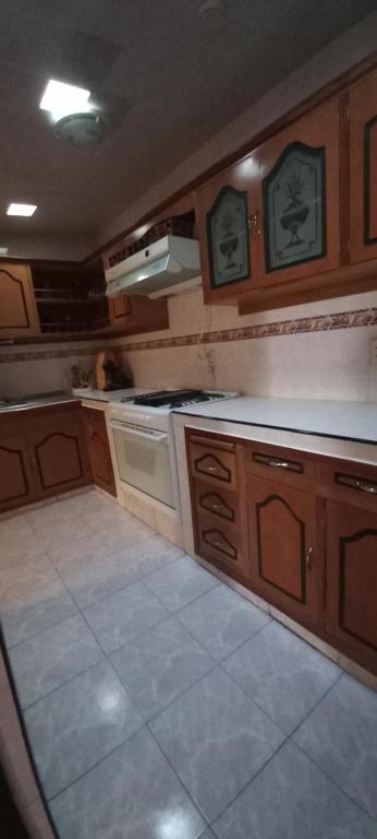uma cozinha com armários de madeira e um forno com placa de fogão em La Casa de la Abuela en Puebla em San Baltasar