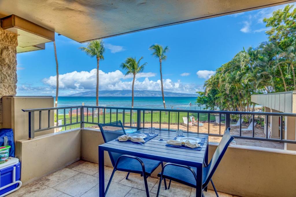 uma mesa e cadeiras numa varanda com vista para a praia em Paki Maui 123 em Kahana