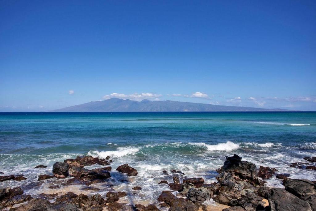 uma vista para o oceano a partir de uma praia rochosa em Noelani 101 em Kahana