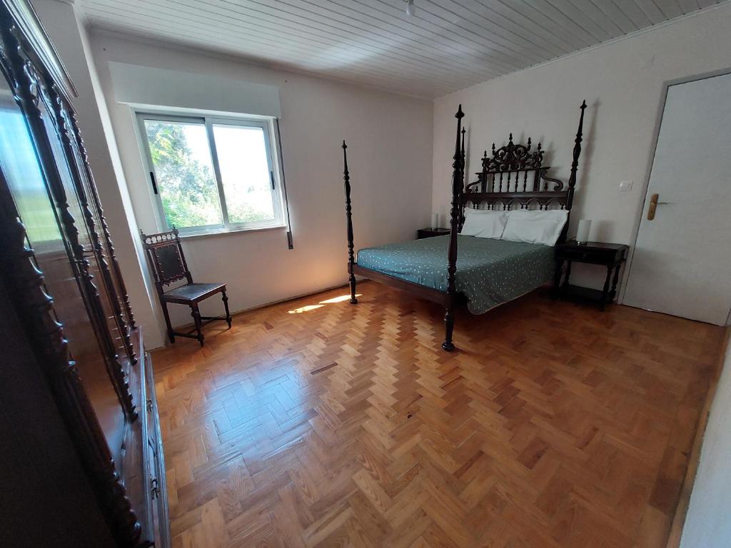 - une chambre avec un lit et du parquet dans l'établissement Casa do Pisco, à Sardoal