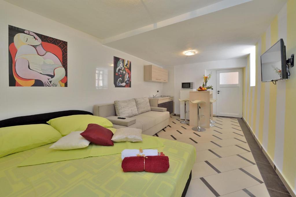 1 dormitorio con 1 cama verde y sala de estar en Apartments Carpe Diem, en Novigrad (Dalmacia)