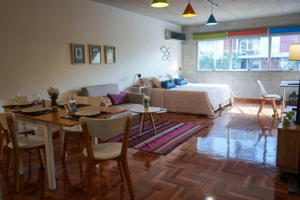 a living room with a bed and a table and chairs at Niceto Studio in Buenos Aires