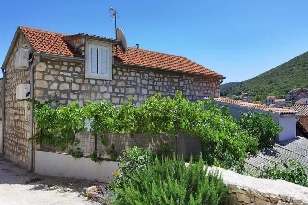 a house with a stone wall and a window at Apartments with WiFi Vis - 19923 in Vis