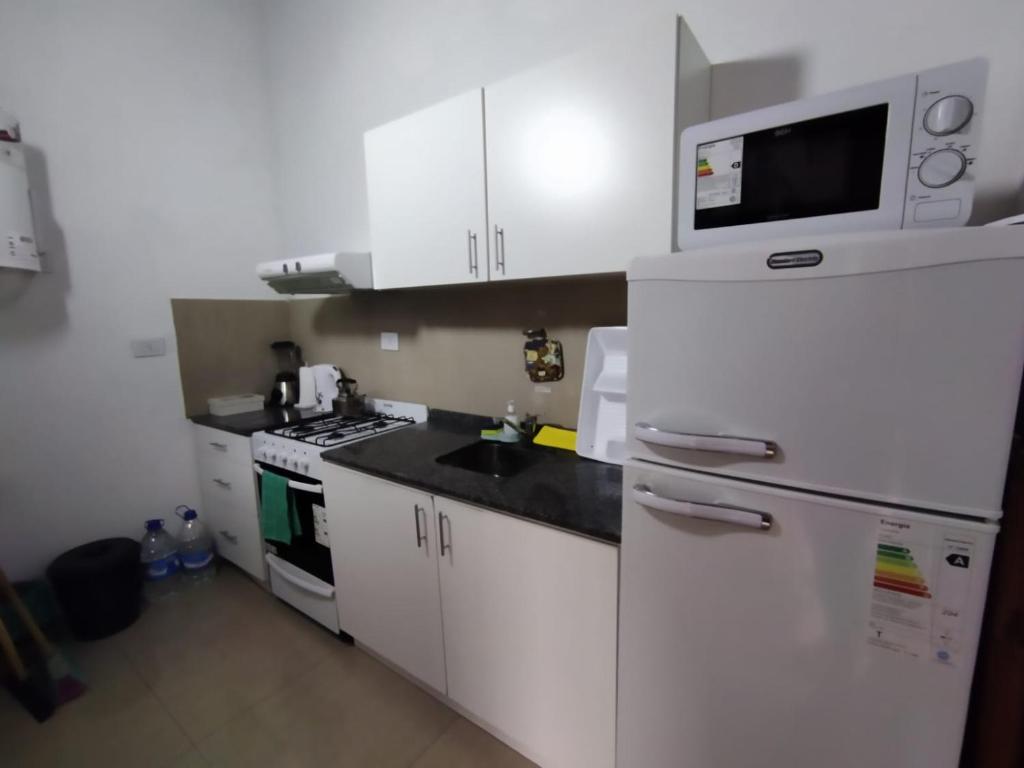 a kitchen with white cabinets and a microwave at FlussHaus VGB in Villa General Belgrano