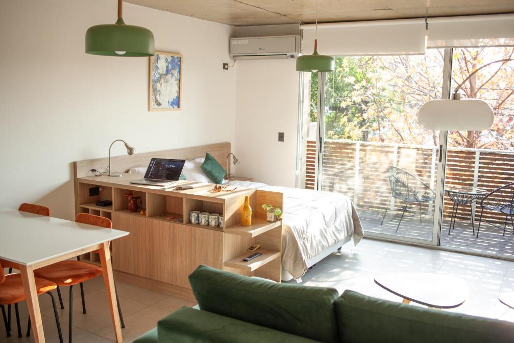 a room with a bed and a desk and a table at Primavera Suites in Buenos Aires