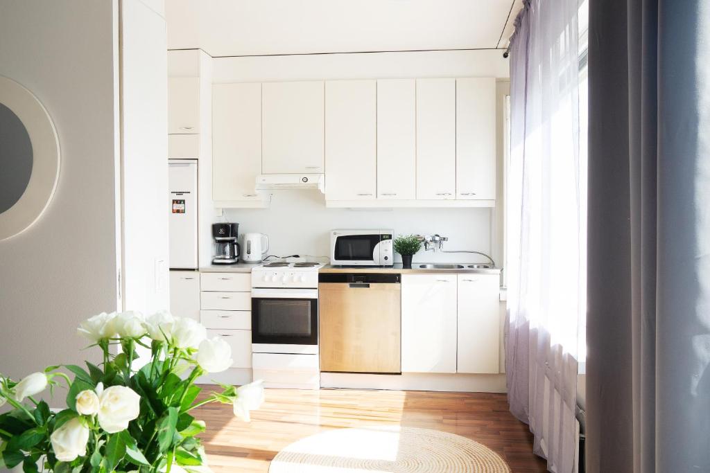 a white kitchen with white cabinets and white appliances at Oulu city center 4-room apartment Parking in Oulu