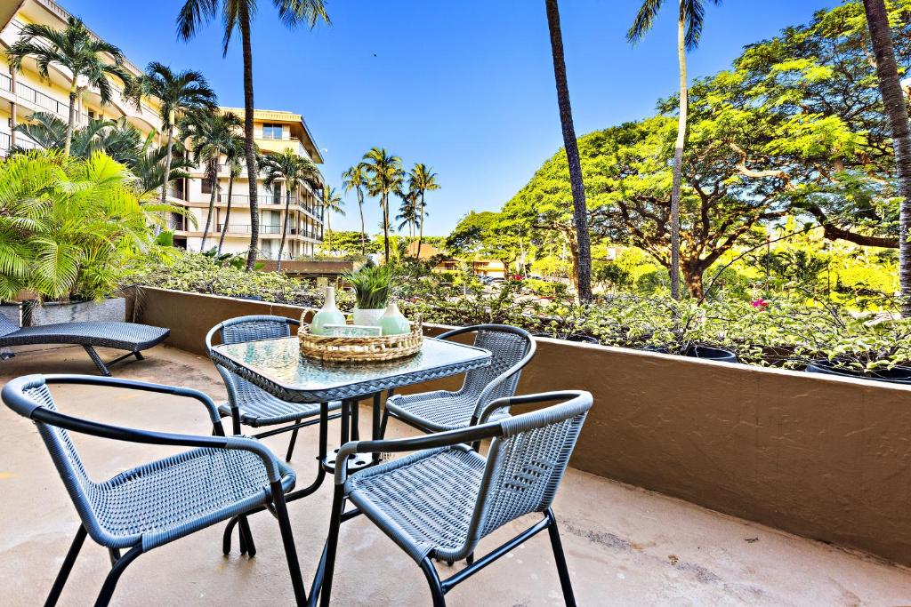 Maui Kaanapali Villas A209 في كانابالي: طاولة وكراسي على فناء به نخيل