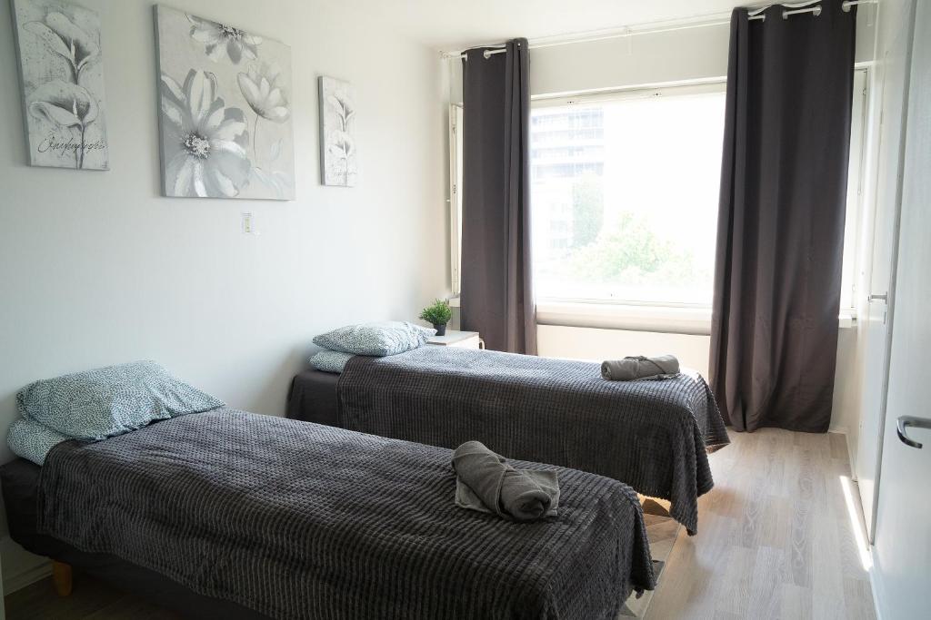 a bedroom with two beds and a window at 2-Room City center, parking in Oulu