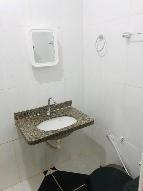 uma casa de banho com um lavatório numa parede branca em Pousada Voadores Jalapão em Mateiros