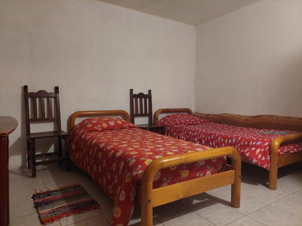 Habitación con 2 camas y 2 sillas. en Pilpilcura en Dina Huapi