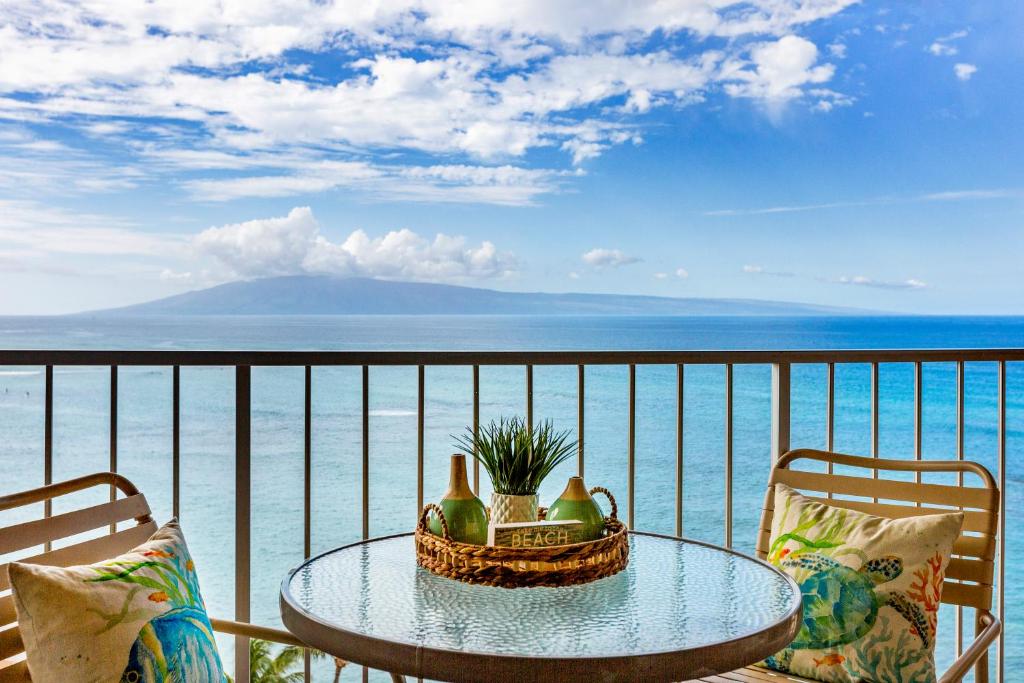 a table on a balcony with a view of the ocean at Royal Kahana 1212 in Kahana