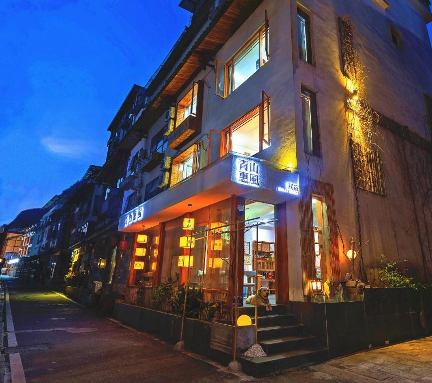 a building with a sign on the front of it at Wally House青山惠风民宿 in Zhangjiajie