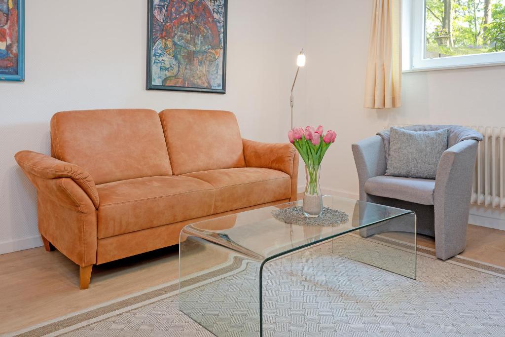 uma sala de estar com um sofá e uma mesa de vidro em Haus Eva Mar am Meer Appartement 6 em Timmendorfer Strand