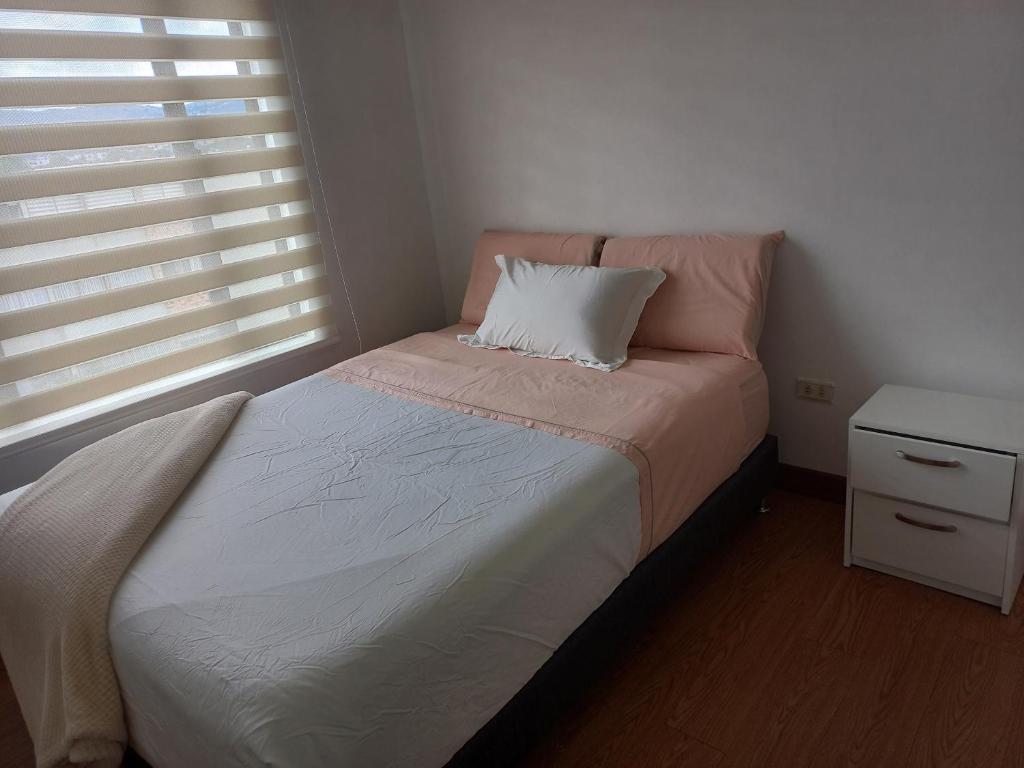 1 dormitorio con cama con almohada y ventana en Habitación con cama doble y baño privado, para descansar, en Bogotá