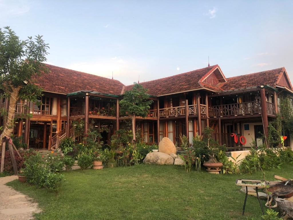 - un grand bâtiment en bois avec une cour devant dans l'établissement Wooden Homestay Đại Lải, à Phúc Yên