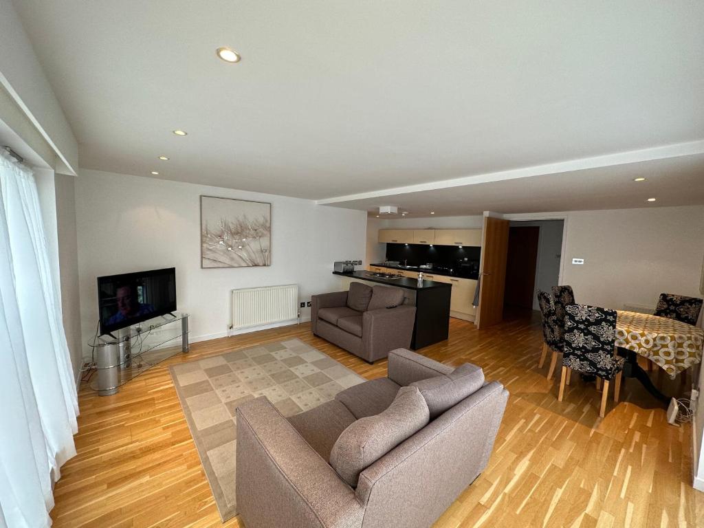a living room with a couch and a tv at Apartment in City Centre Glasgow in Glasgow